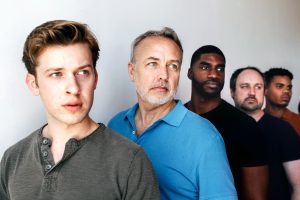 Five men of varying ages standing in line.