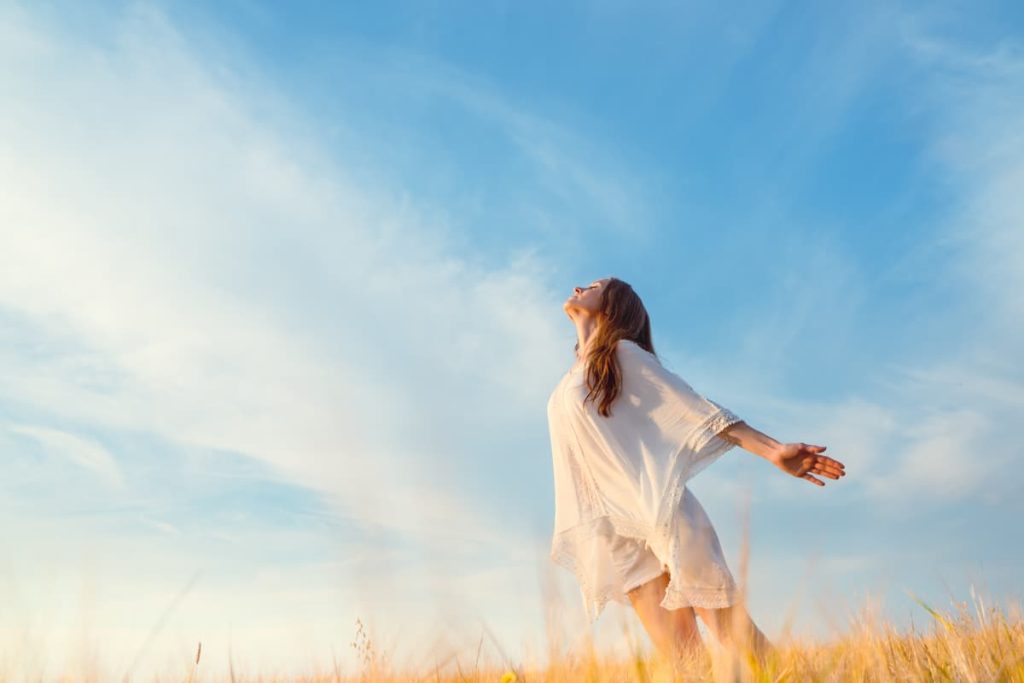 A women in a wheat field looking upward towards God.