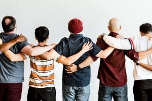 A group of men standing together arm in arm.