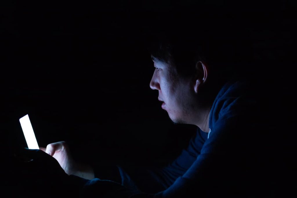 A man in the dark on his phone.