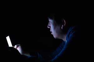 A man in the dark on his phone.